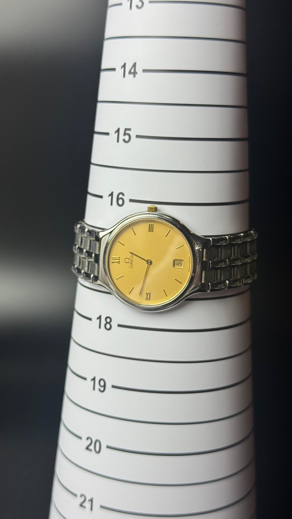 Omega – złota tarcza, cyfry rzymskie, datownik, srebrna bransoleta
