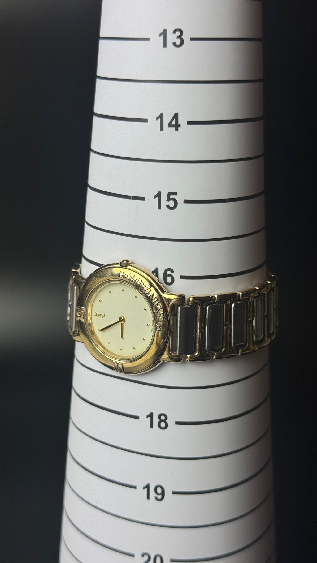 Yves Saint Laurent YSL – kremowa tarcza, złota koperta, dwukolorowa bransoleta