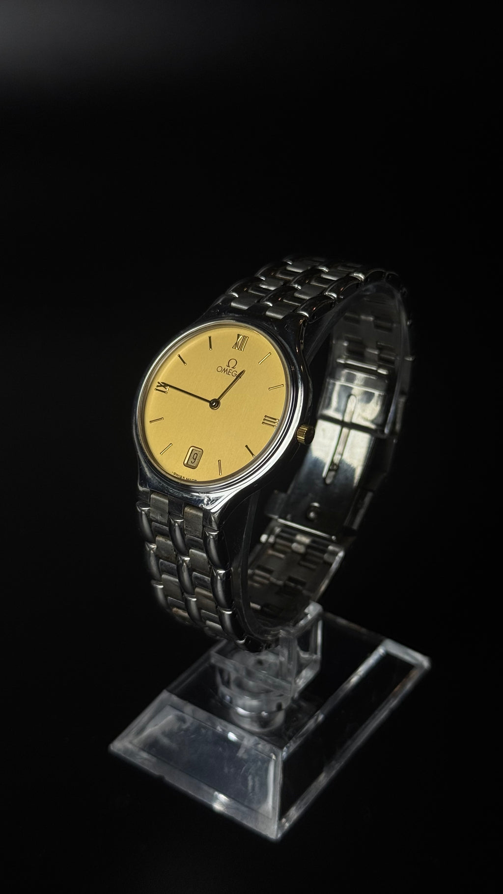 Omega – złota tarcza, cyfry rzymskie, datownik, srebrna bransoleta
