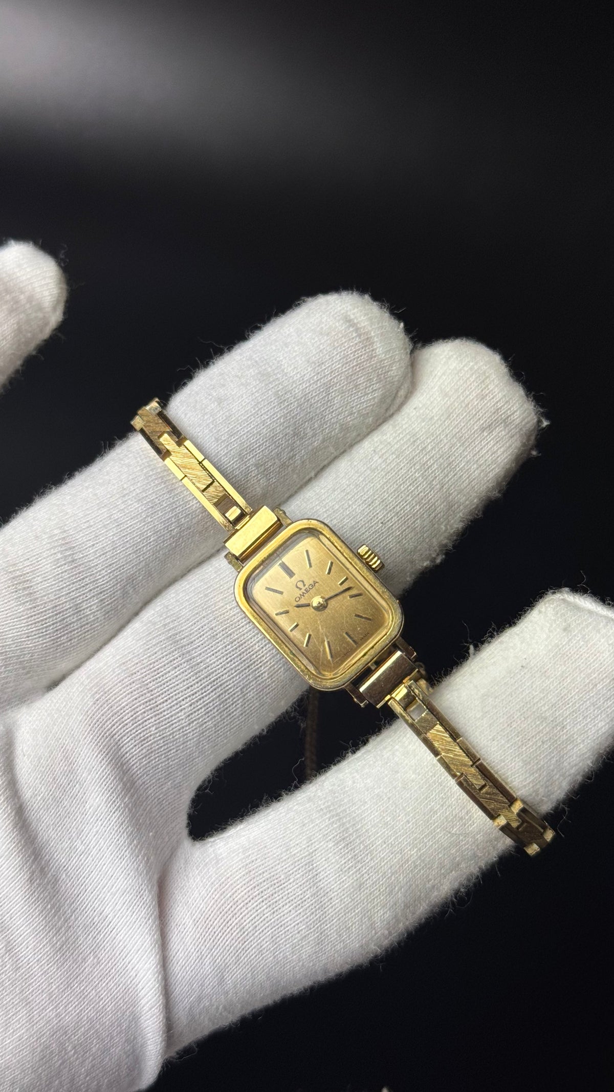 Omega – prostokątny zegarek vintage w złotym kolorze na ozdobnej bransolecie
