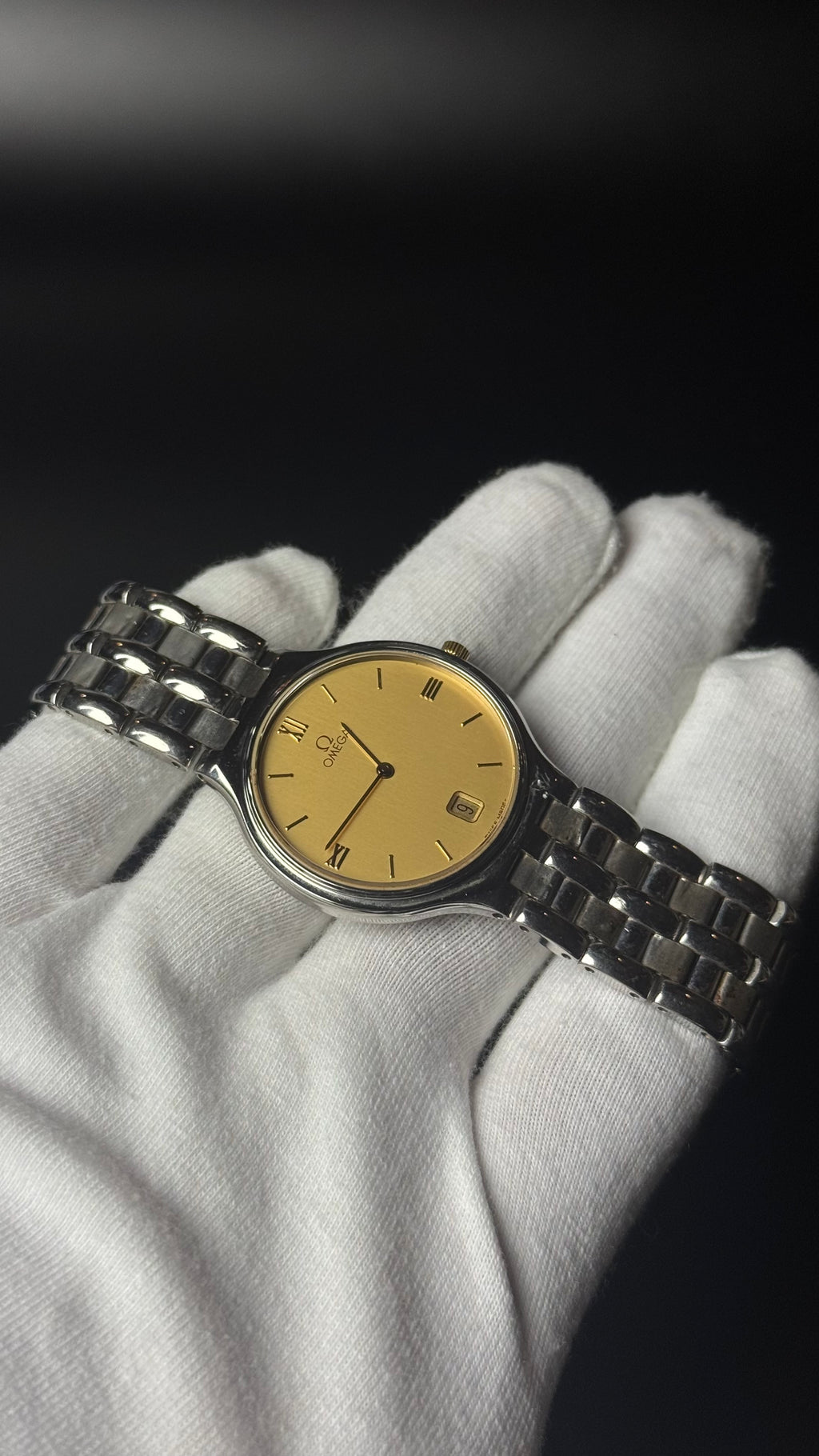 Omega – złota tarcza, cyfry rzymskie, datownik, srebrna bransoleta